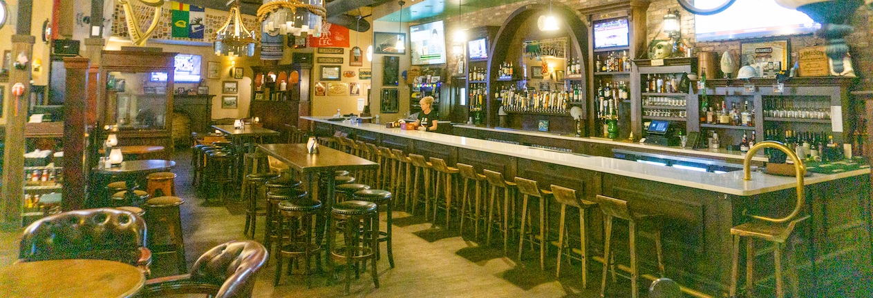 Lively bar atmosphere inside Fionn MacCool's Irish Pub with patrons and warm lighting